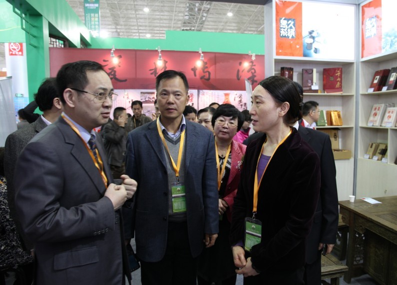 久扬茶业青海总经销魏总（左一）向湖南省委常委统战部长李薇薇（右一）汇报工作